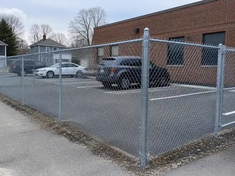 Galvanized chain link perimeter fence around a commercial parking lot in Massachusetts