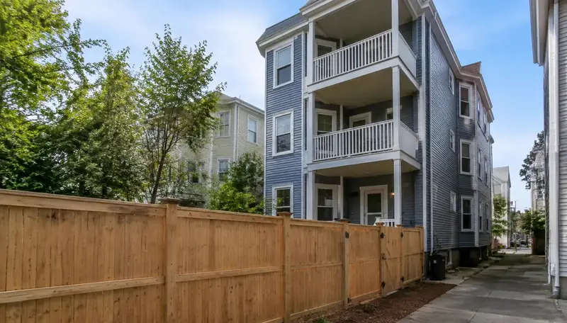 Privacy fence dividing the yard of a triple-decker in Greater Boston